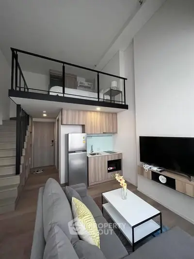 Modern loft apartment with stylish living room and kitchen, featuring high ceilings and mezzanine bedroom.