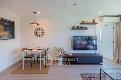 Modern living room with dining area, stylish decor, and wall-mounted TV in a cozy apartment.