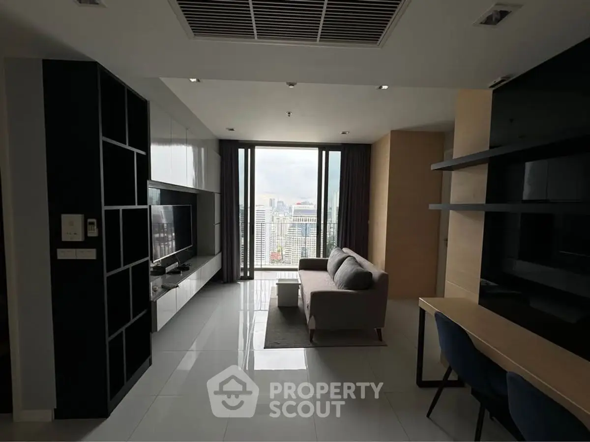 Modern living room with city view, sleek furniture, and large windows in a high-rise apartment.
