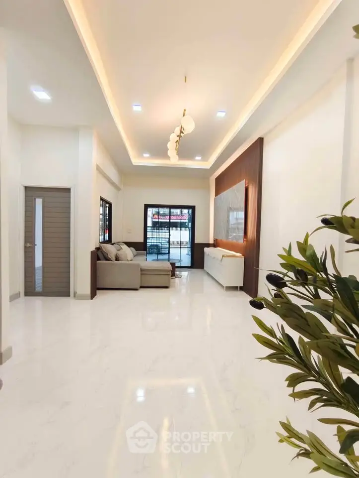 Spacious modern living room with elegant lighting and marble flooring, perfect for stylish urban living.