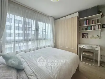 Cozy bedroom with large window and built-in wardrobe in modern apartment