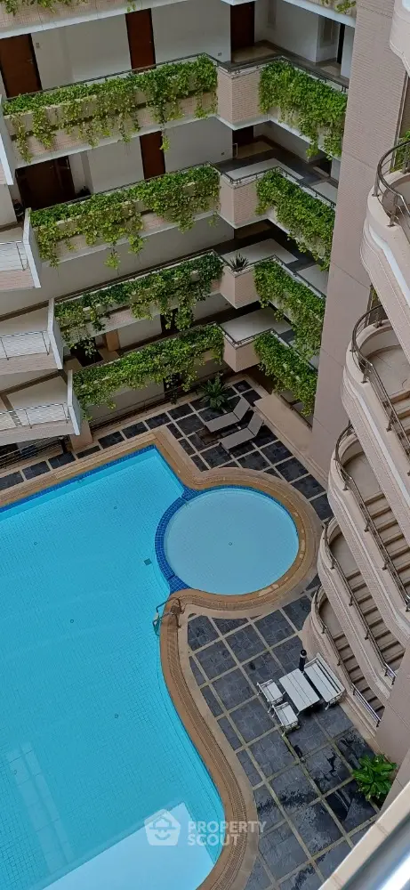 Luxurious apartment complex with stunning pool and lush greenery