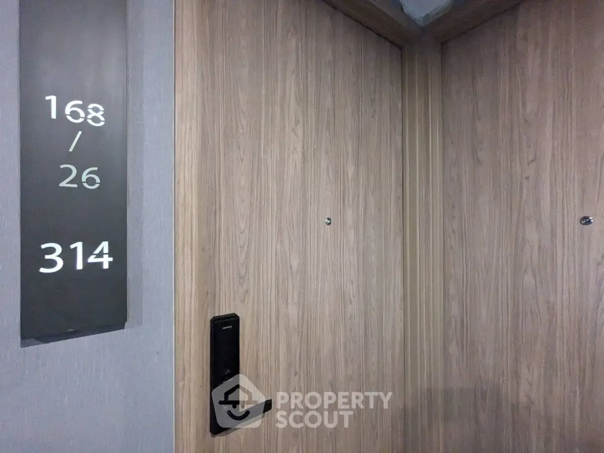 Modern apartment entrance with sleek wooden door and digital lock