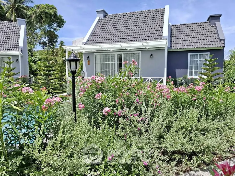 Charming cottage-style home with lush garden and vibrant flowers, perfect for serene living.