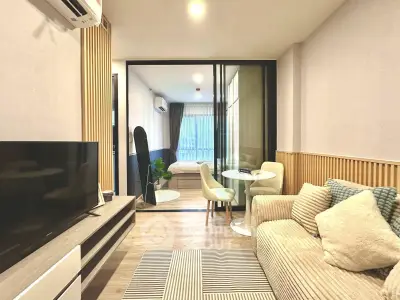 Modern living room with cozy sofa, TV, and dining area in stylish apartment