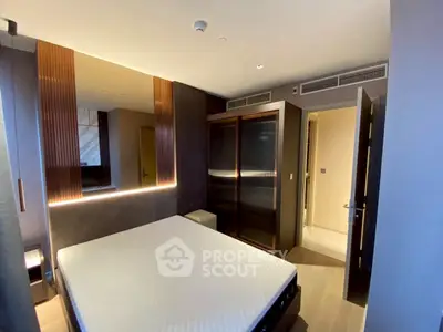 Modern bedroom with sleek design and built-in wardrobe, featuring ambient lighting.