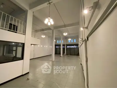 Spacious industrial-style interior with high ceilings and modern lighting, perfect for versatile commercial use.