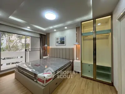 Modern bedroom with large window and stylish lighting, featuring a new bed and spacious wardrobe.