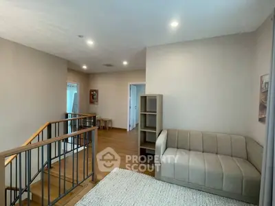 Spacious modern living area with cozy sofa and wooden flooring, perfect for relaxation and comfort.