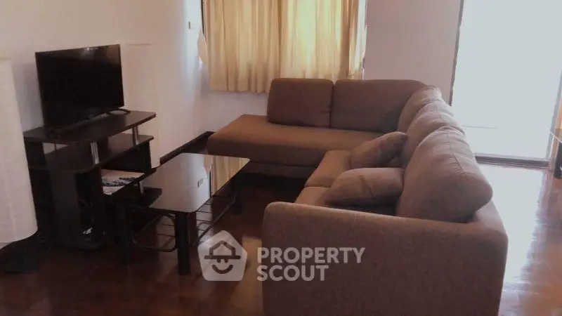 Cozy living room with brown sectional sofa and modern TV setup.