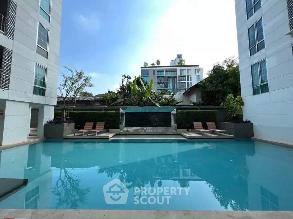 Luxurious apartment complex with a stunning outdoor pool and modern architecture.