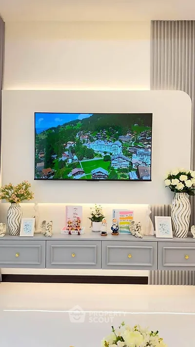 Elegant living room with modern decor and wall-mounted TV displaying scenic view.