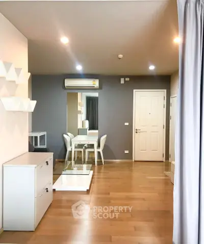 Modern living room with wooden flooring, stylish furniture, and air conditioning in a cozy apartment.