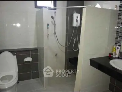Modern bathroom with sleek shower and contemporary fixtures in stylish real estate property.