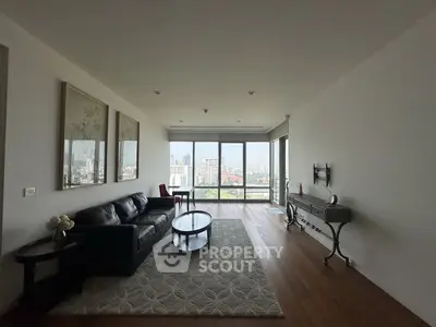 Spacious living room with city view, elegant decor, and large windows in modern apartment.