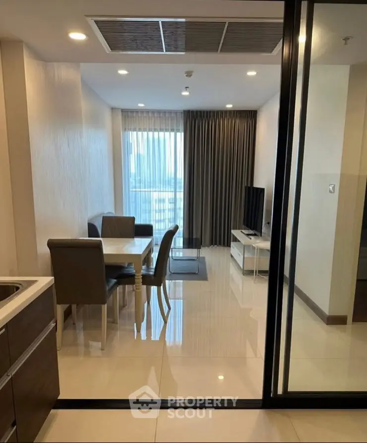 Modern living room with dining area and large window view in a stylish apartment.