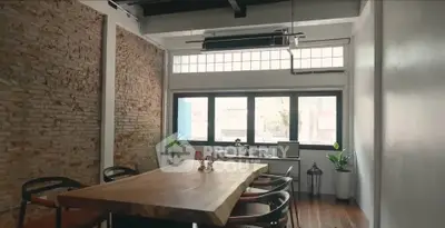Chic industrial-style dining room with exposed brick and large wooden table.