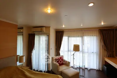 Spacious bedroom with cozy seating and natural light