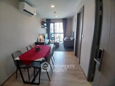 Modern living room with dining area and balcony view in a stylish apartment.