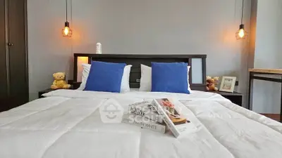 Cozy bedroom with modern lighting and stylish decor, perfect for relaxation.