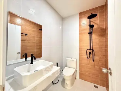 Modern bathroom with sleek fixtures and wood accent wall