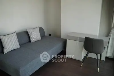 Modern living room with sleek gray sofa and stylish desk, perfect for urban living.