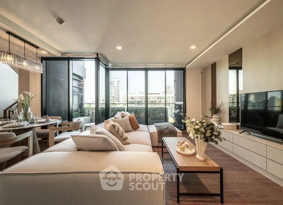 Luxurious modern living room with large windows and elegant decor, offering a stunning city view.