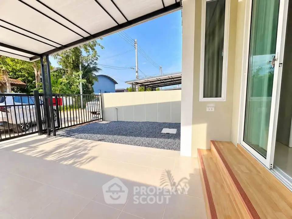 Modern home entrance with covered patio and garden view, perfect for relaxation.