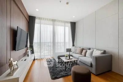 Modern living room with large windows, stylish furniture, and wooden flooring.