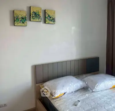 Modern bedroom with stylish headboard and abstract art, perfect for a cozy retreat.