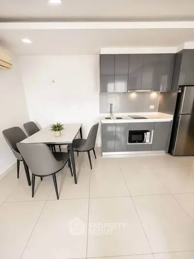 Modern kitchen with sleek cabinetry and dining area in a stylish apartment.