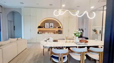 Modern open-plan living room with elegant dining area and stylish lighting