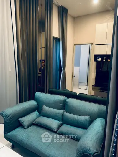 Cozy living room with teal sofa and modern decor, perfect for relaxation.