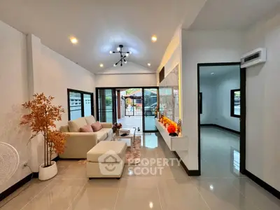 Modern living room with stylish decor and large glass doors leading to patio.