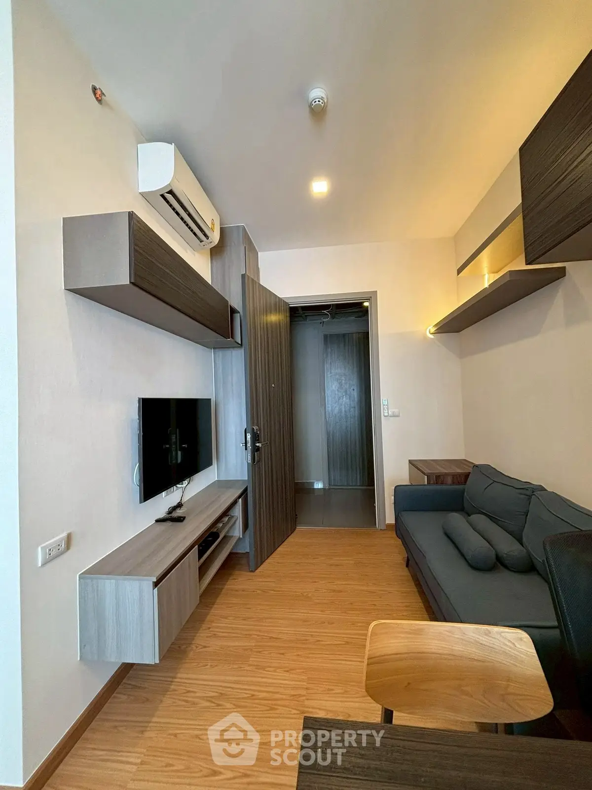 Modern living room with sleek furniture and wooden flooring in a stylish apartment.