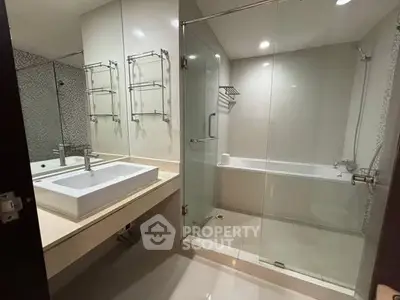 Modern bathroom with glass shower and bathtub in luxury apartment