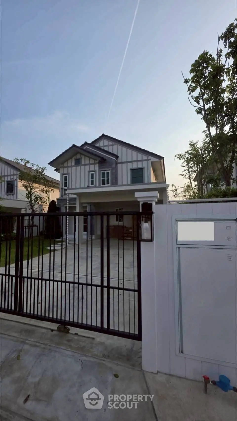 Modern two-story house with spacious driveway and gated entrance
