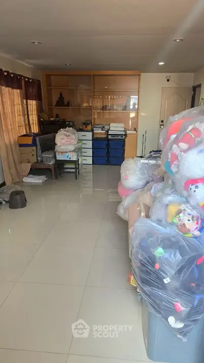 Spacious room with glossy tiles and ample storage space, ideal for versatile use.