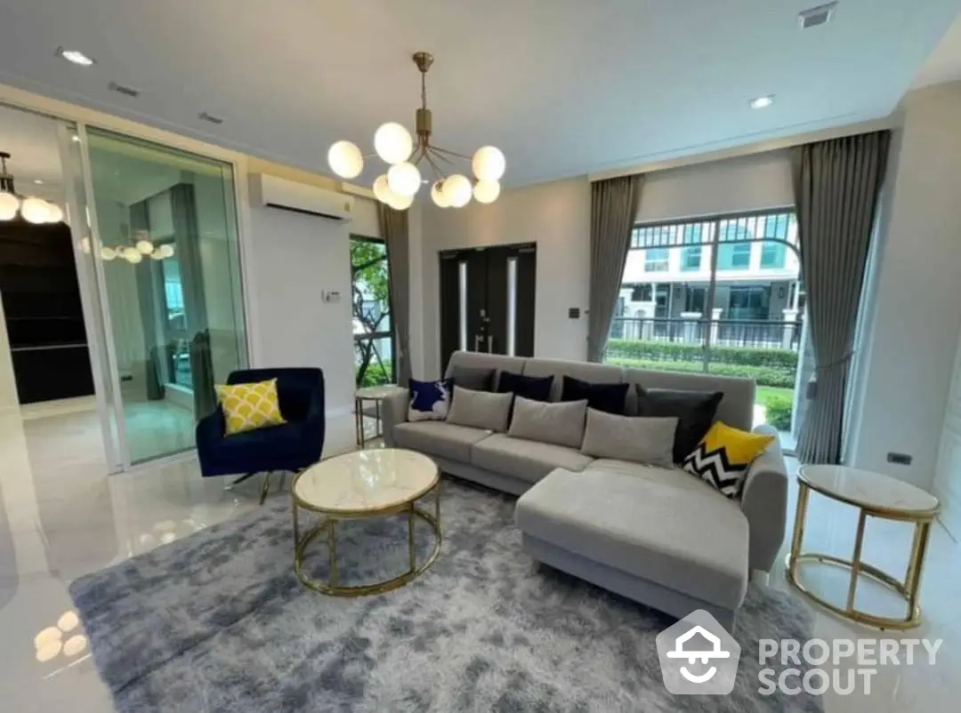 Spacious living room with modern decor, plush seating, elegant lighting, and seamless indoor-outdoor flow, perfect for entertaining and relaxation.