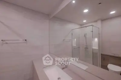 Modern bathroom with glass shower and sleek fixtures in a contemporary home.