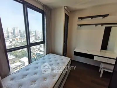 Modern bedroom with city view, featuring a single bed and stylish built-in desk and shelves.