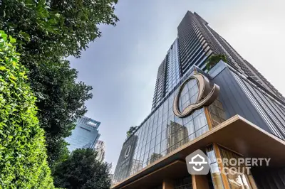 Stunning modern high-rise building with sleek glass facade and lush greenery.