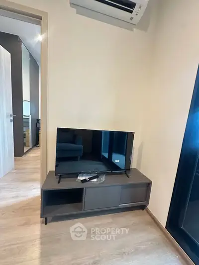 Modern living room with sleek TV stand and air conditioning, showcasing minimalist design and comfort.