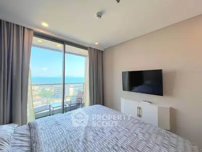 Modern bedroom with balcony and stunning ocean view in luxury apartment
