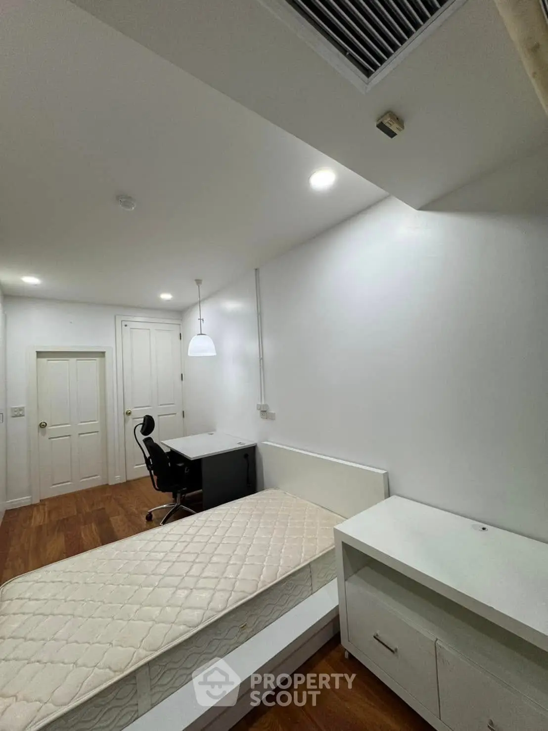 Spacious bedroom with study desk and modern lighting, ideal for comfort and productivity.