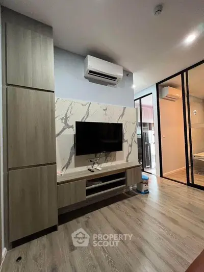Modern living room with stylish TV setup and air conditioning in a contemporary apartment.