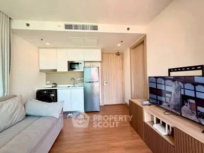 Modern living room with compact kitchen and sleek appliances