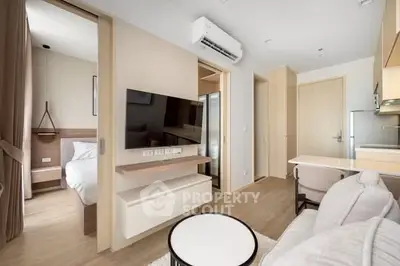 Modern apartment interior with open living room and bedroom, featuring sleek furniture and neutral tones.