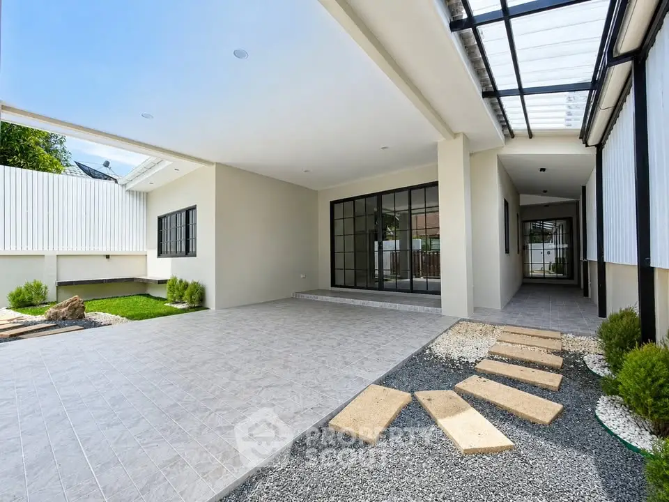 Modern home exterior with spacious covered patio and stylish landscaping.