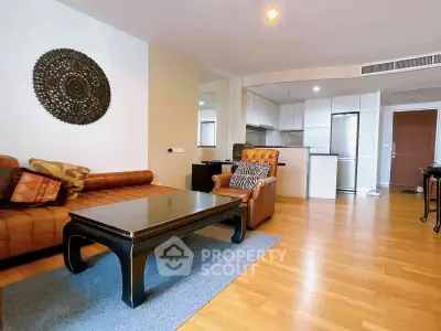 Spacious living room with stylish furniture and open kitchen layout in modern apartment.